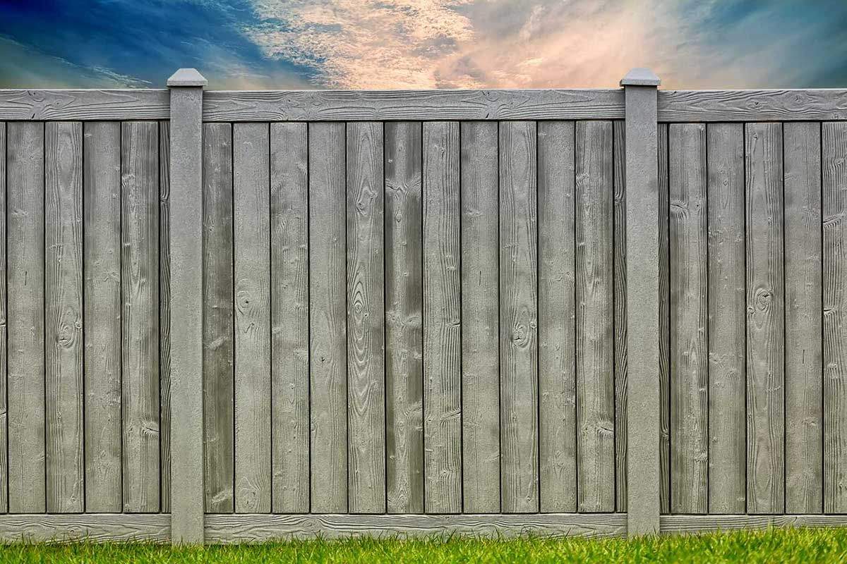 A wooden fence is sitting in the middle of a lush green field.