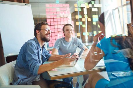 A group of people are sitting at a table having a meeting.