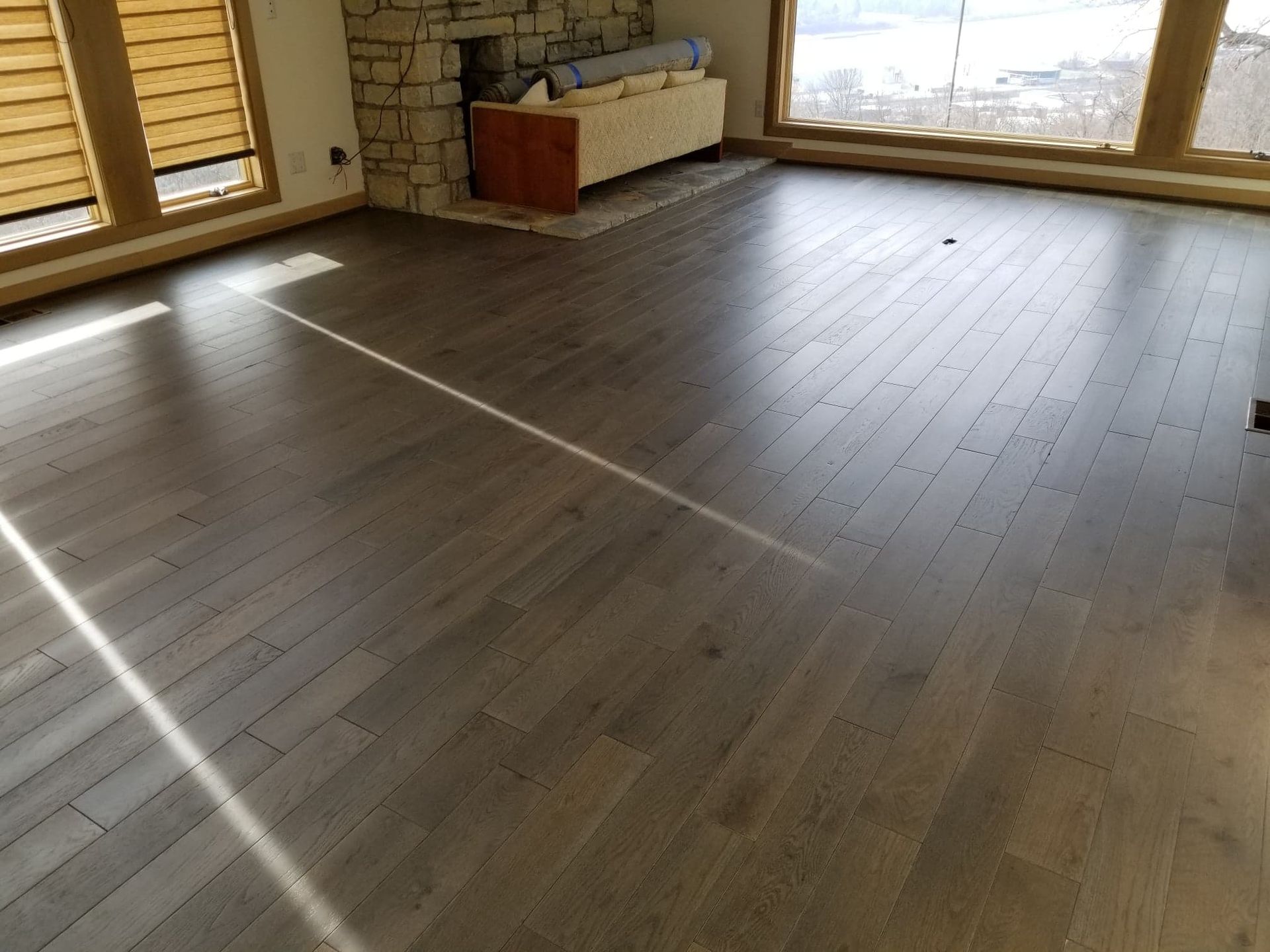 A living room with hardwood floors and a fireplace.