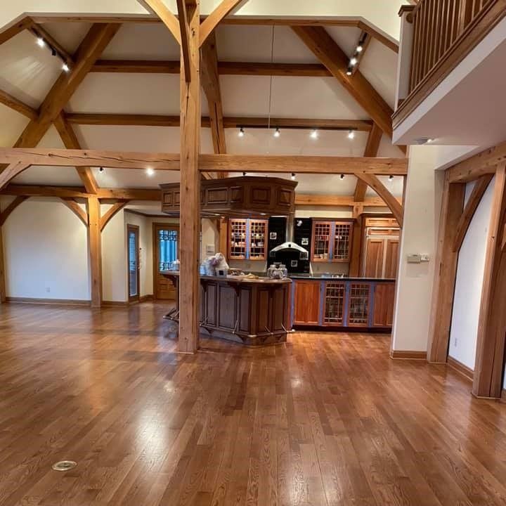 A kitchen with hardwood floors and wooden beams
