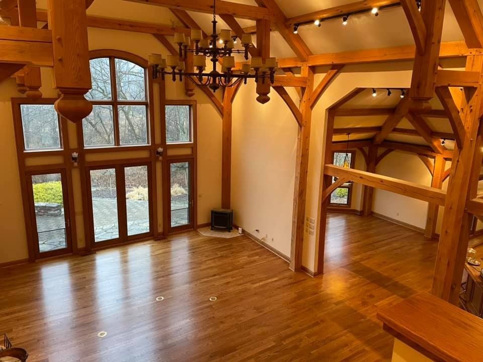 A large empty room with wooden beams and a chandelier hanging from the ceiling.