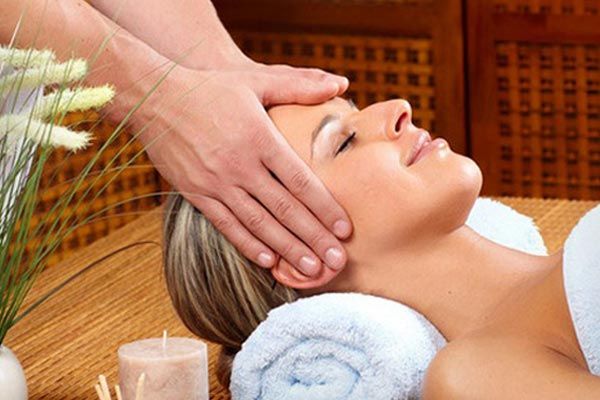 A woman is getting a head massage at a spa.