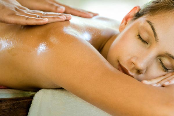 A woman is laying on a table getting a massage