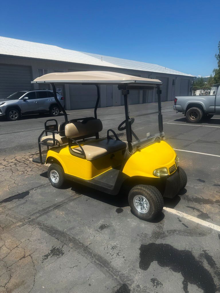 Yellow golf cart parked in a lot