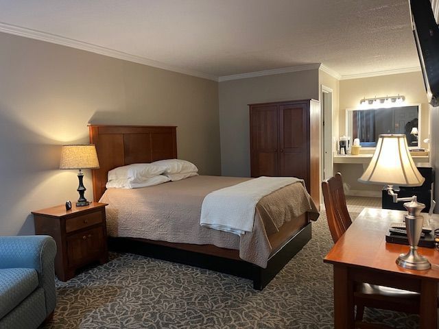 A hotel room with a king size bed and a desk