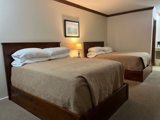 A hotel room with two beds and a lamp