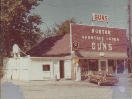 A norton sporting goods store with a car parked in front of it