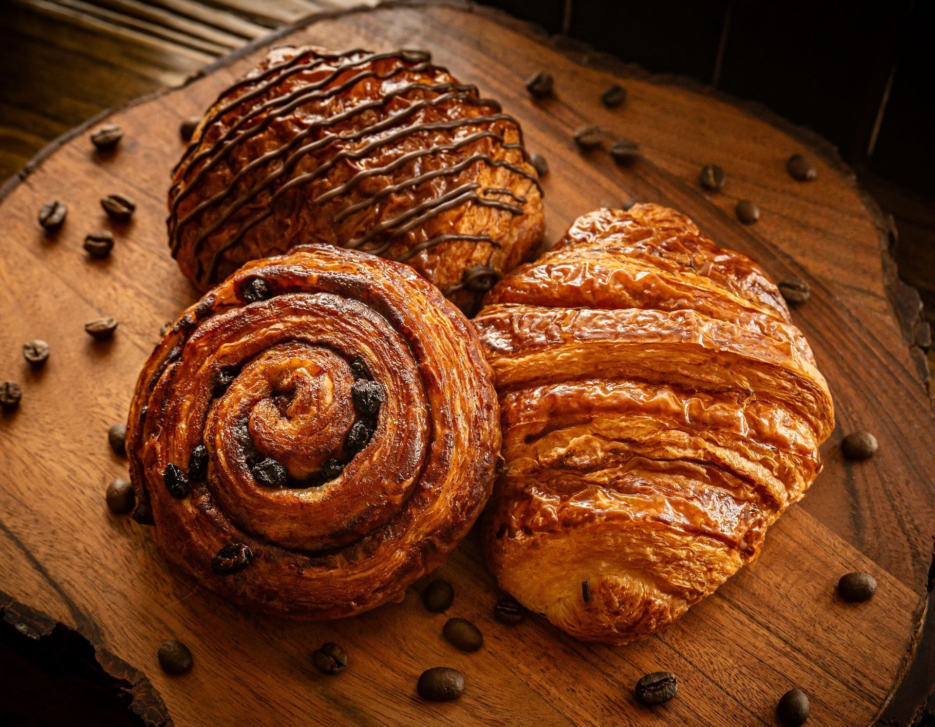 Three pastries are sitting on a wooden cutting board.