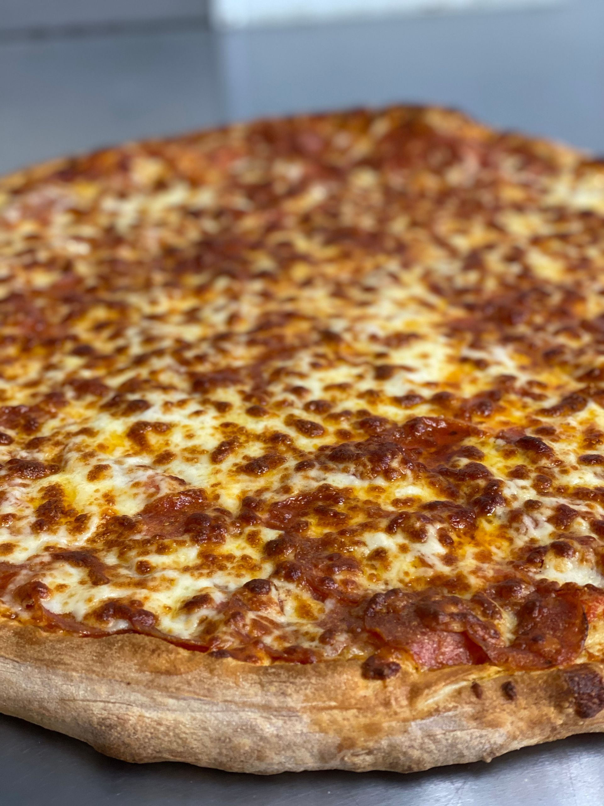 a pizza with cheese and pepperoni is sitting on a table