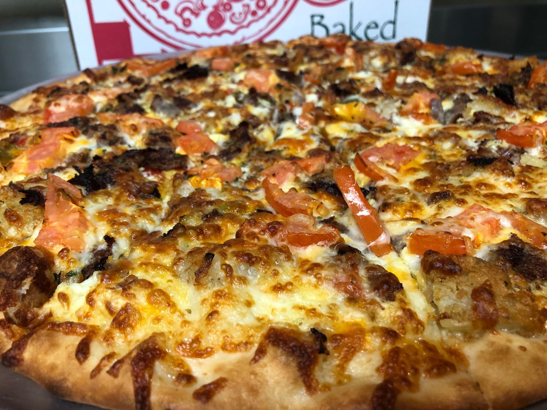 a pizza with a lot of toppings on it is sitting on a pizza pan