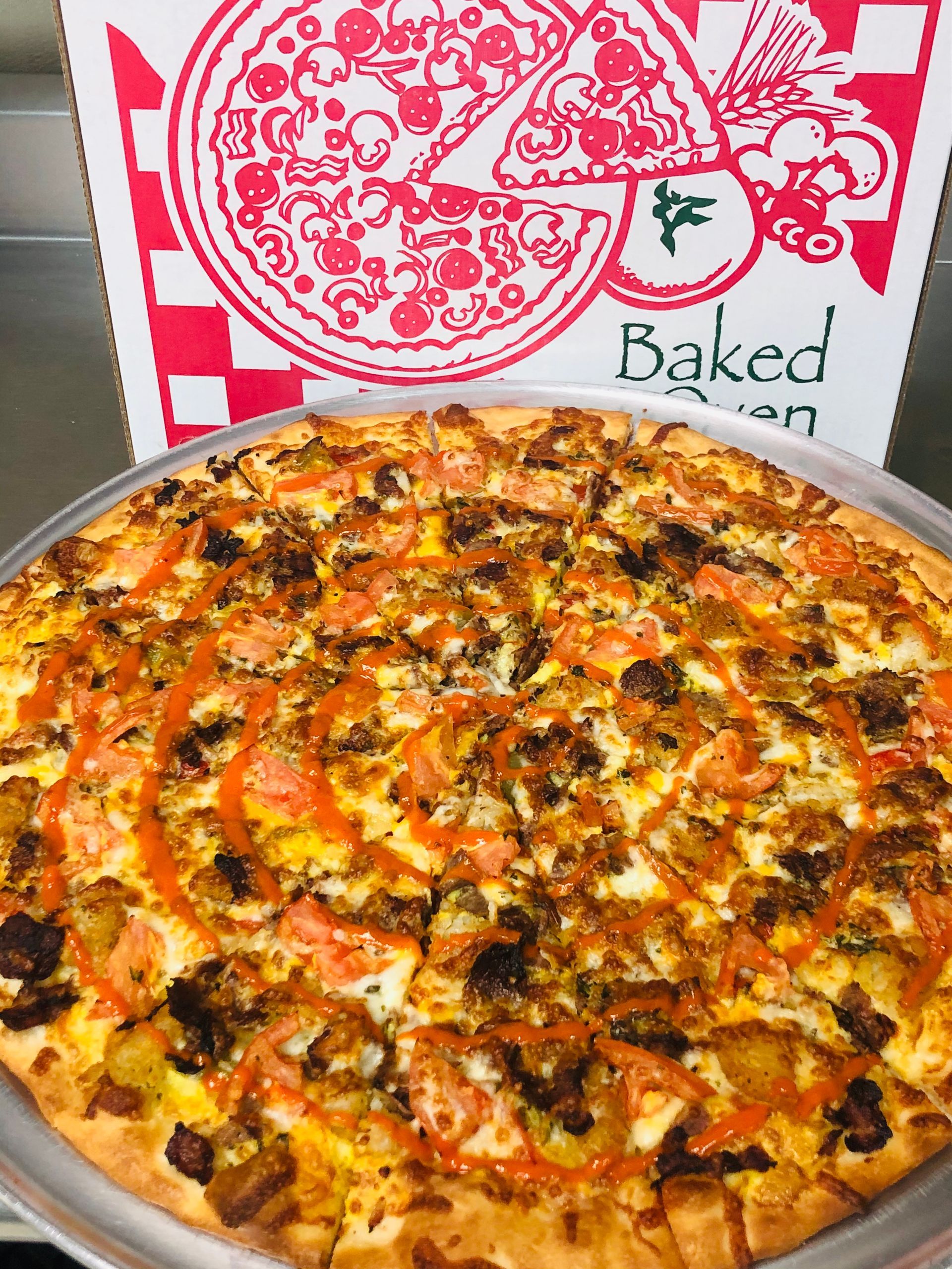 a pizza is sitting in front of a box that says baked