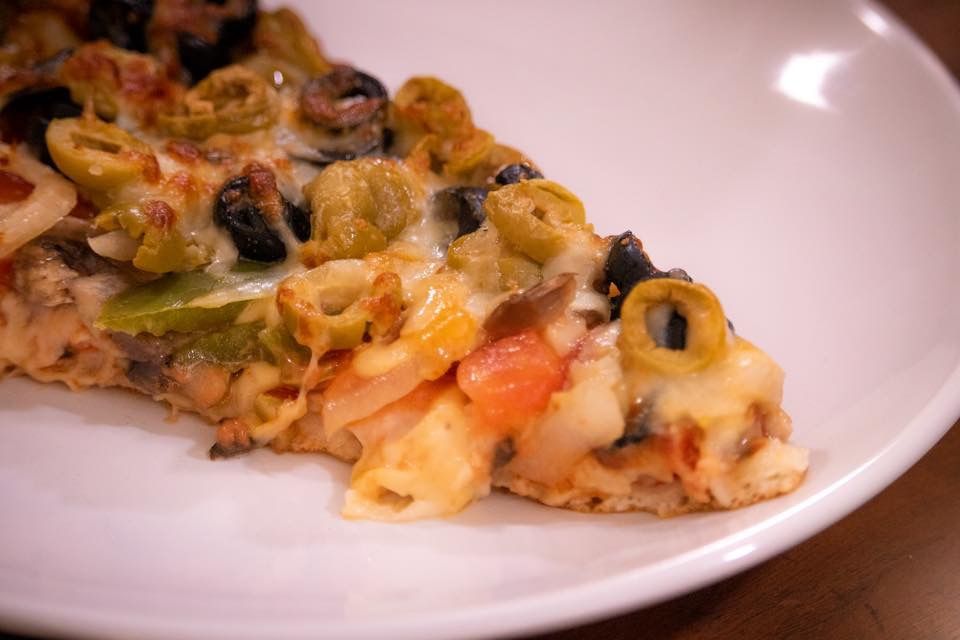 a close-up of a slice of pizza on a white plate