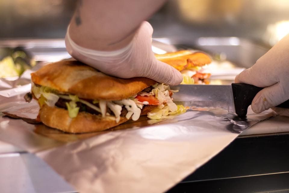 a long sub sandwich being sliced