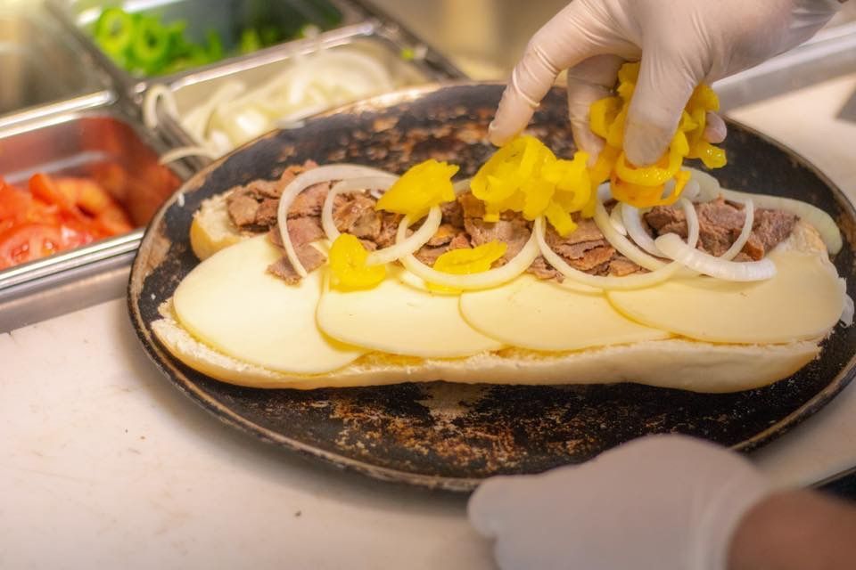 a person is making a sub sandwich on a pan