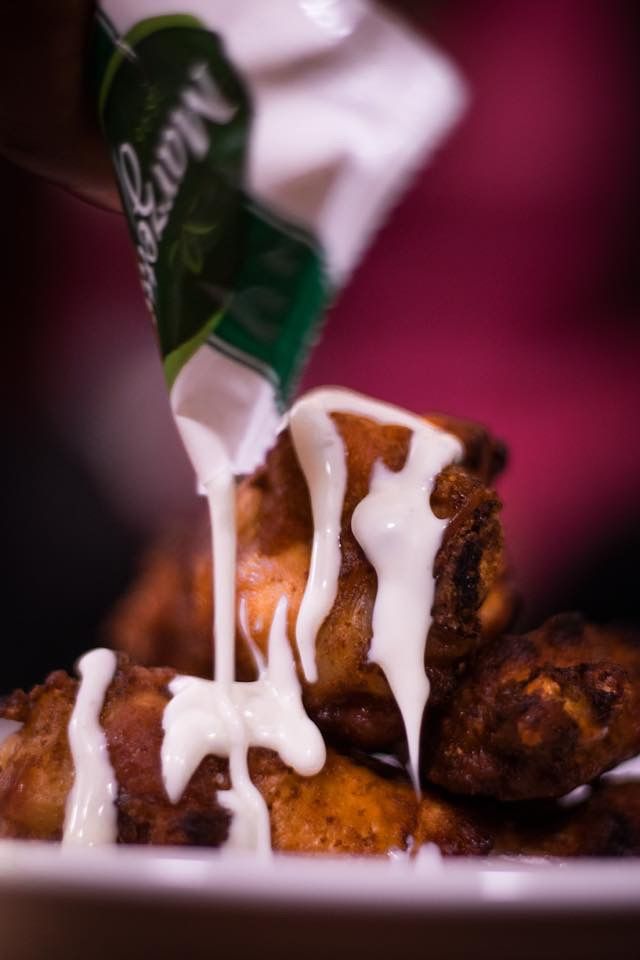a bag of mayonnaise is being poured over fried food