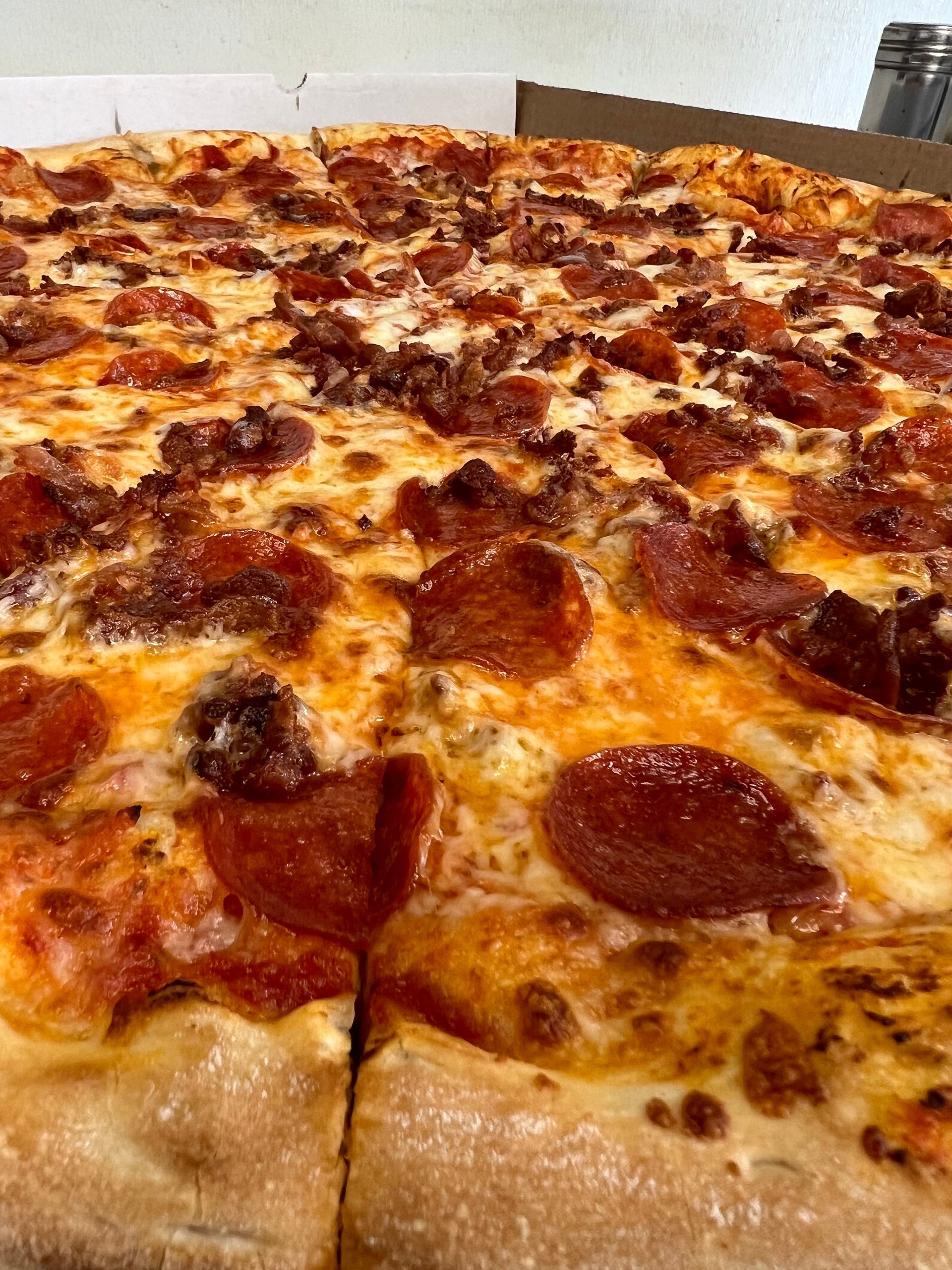 a close-up of a pepperoni pizza in a box