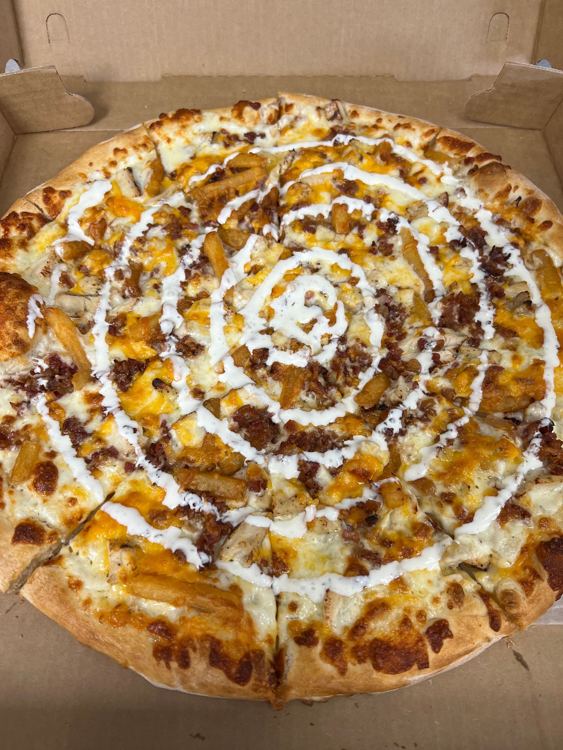 a pizza with a swirl of toppings is in a box