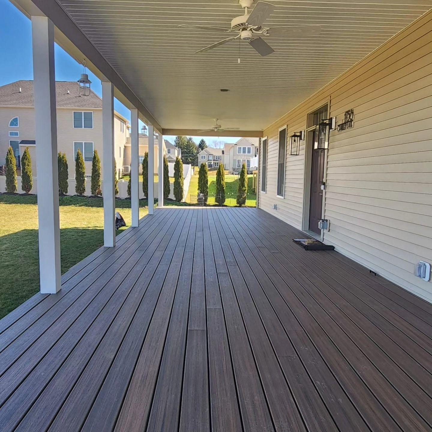 A large wooden deck with a ceiling fan