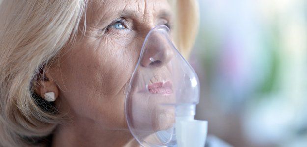An old woman using nebulizer