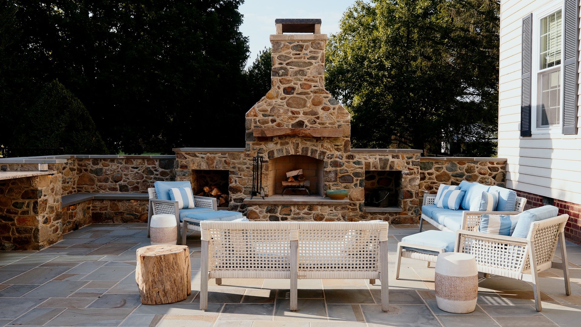 A patio with a fireplace and a couch and chairs