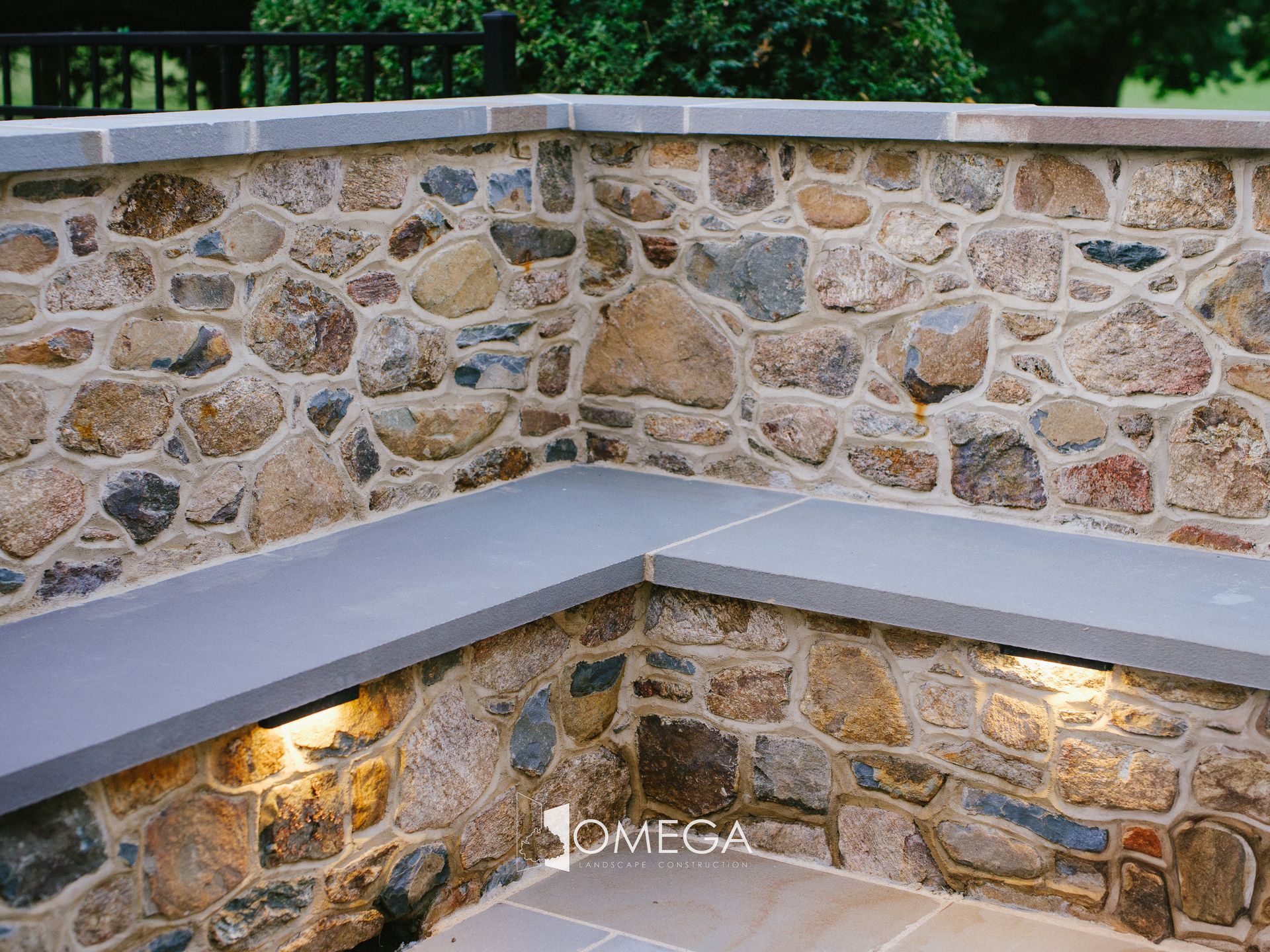 A stone wall with a bench in the middle of it.