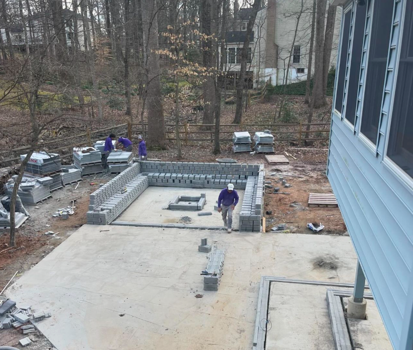 A man in a purple shirt is standing in the middle of a construction site