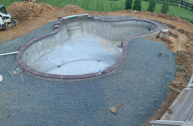 A large swimming pool is being built in a backyard