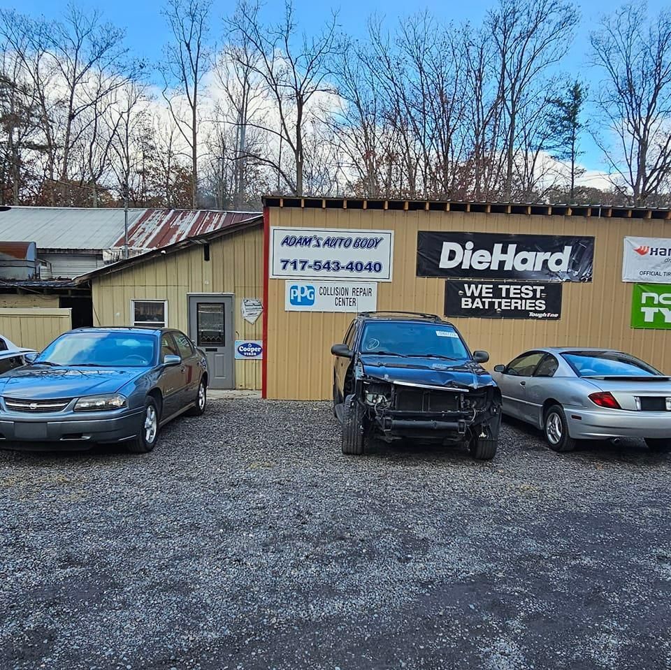Cars parked in front of an auto shop with a 