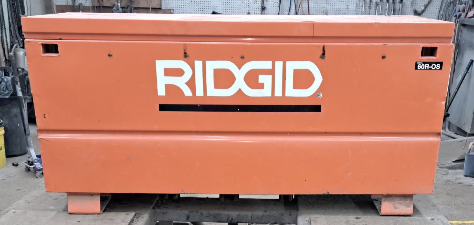 Orange RIDGID tool chest on wheels with a white logo in a workshop setting