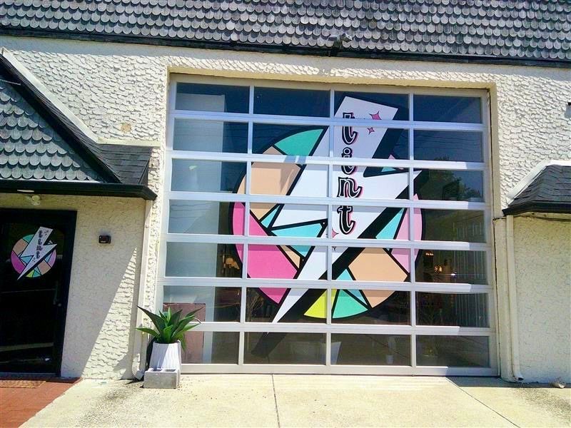 Colorful geometric mural on a large garage door on a building exterior