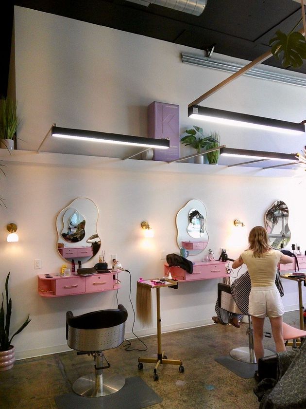 People setting up and serving at a bright café counter with chairs and large windows
