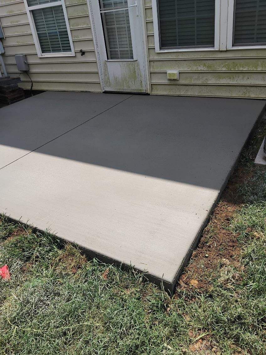 Concrete wheelchair ramp leading to a house entrance beside a front door and windows