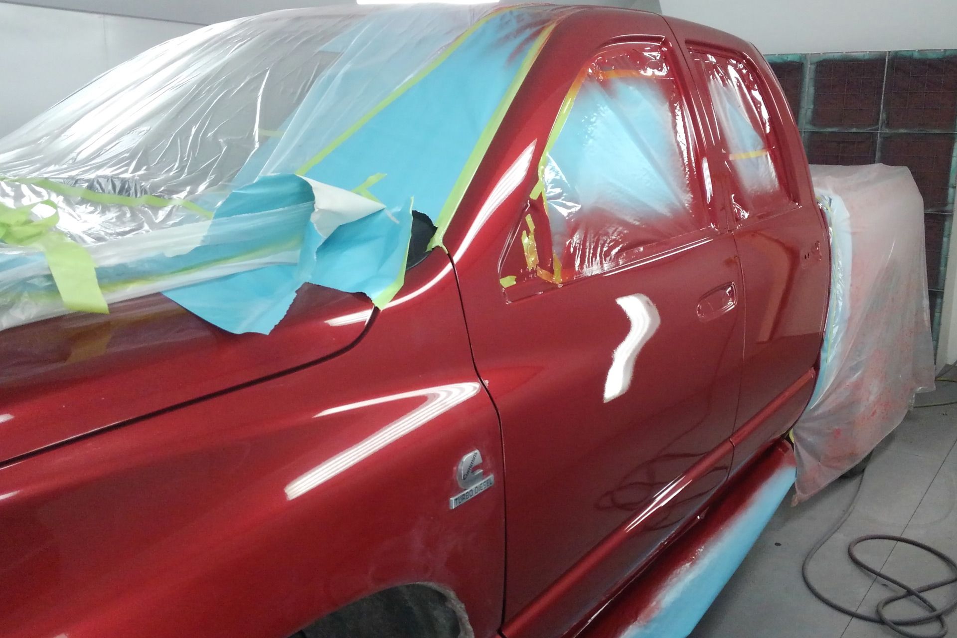 a red truck is being painted in a garage
