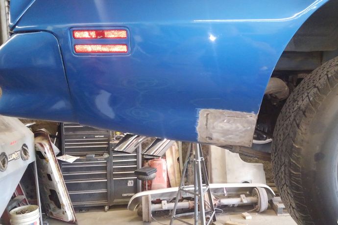 a blue car is sitting on a lift in a garage