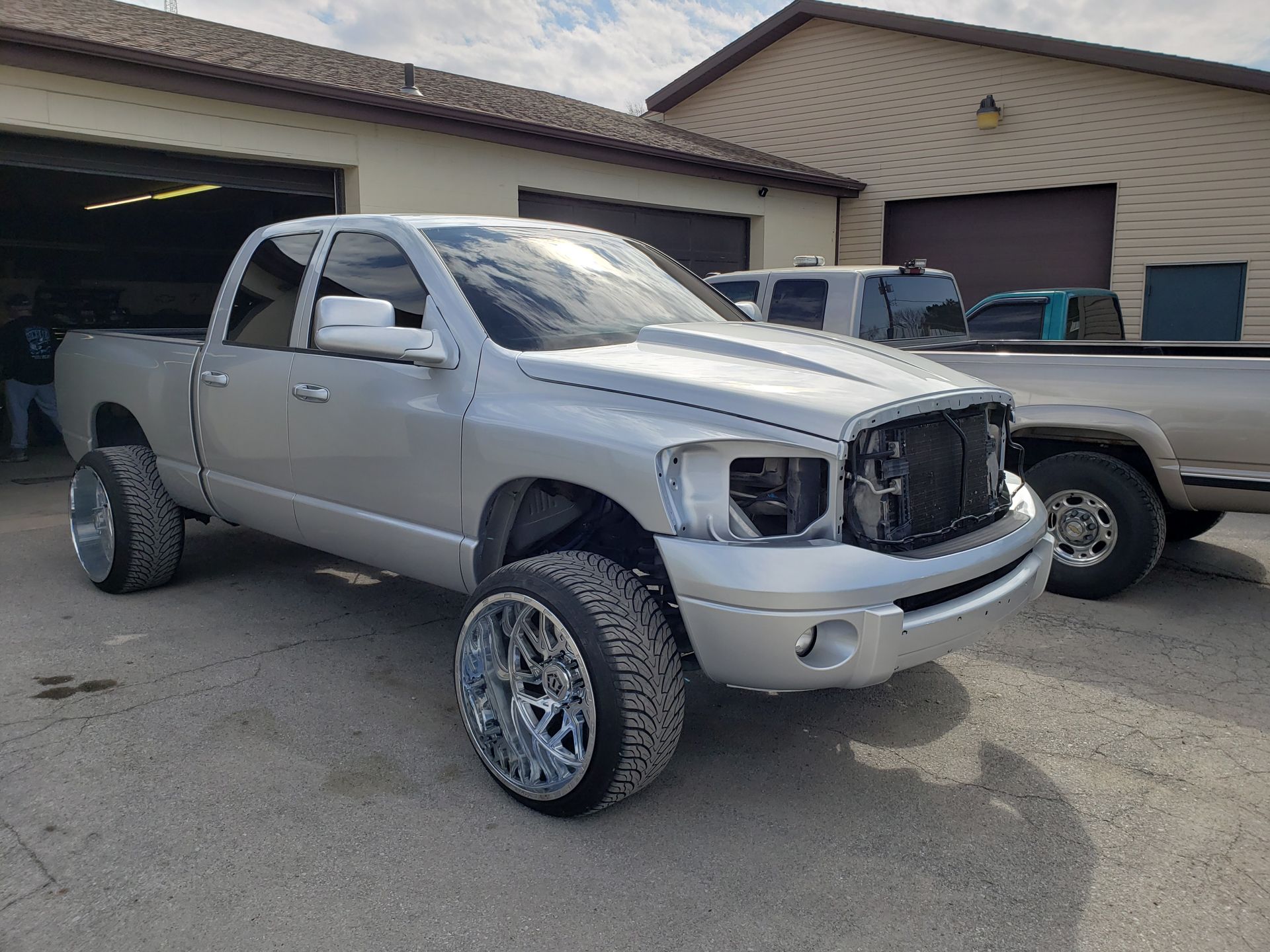 a silver truck is parked in front of a garage