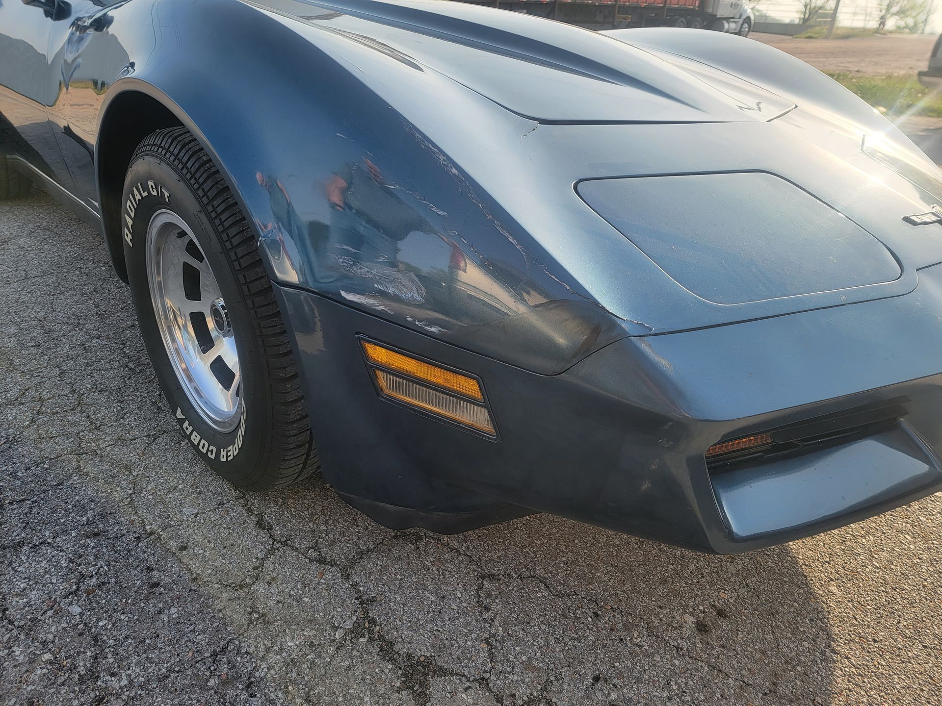 a blue corvette is parked on the side of the road