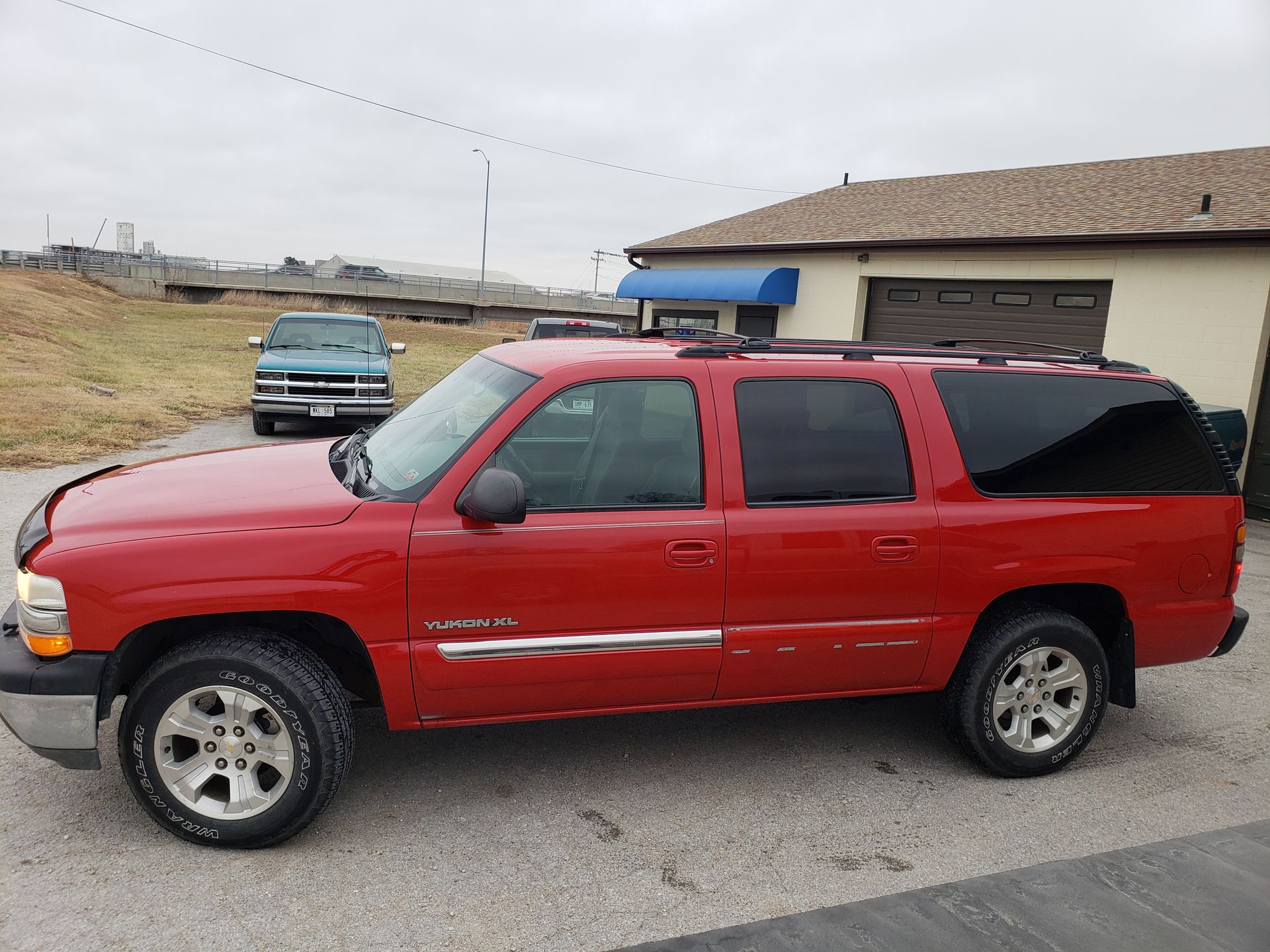a red chevrolet suburban is parked in front of a building