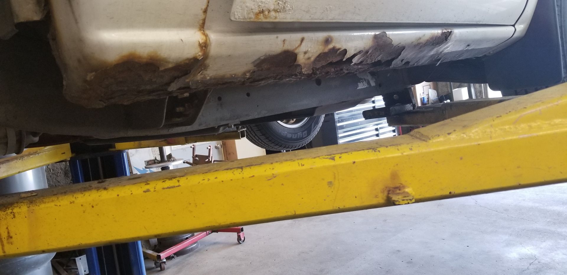 a car is sitting on a yellow lift in a garage