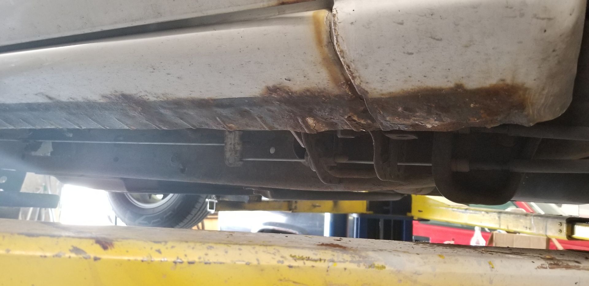 a car is sitting on top of a yellow lift in a garage