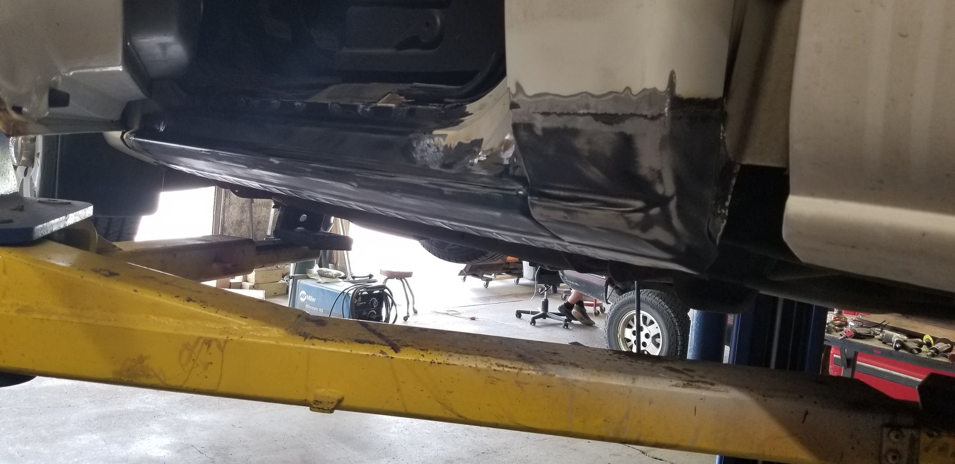 a car is sitting on a yellow lift in a garage
