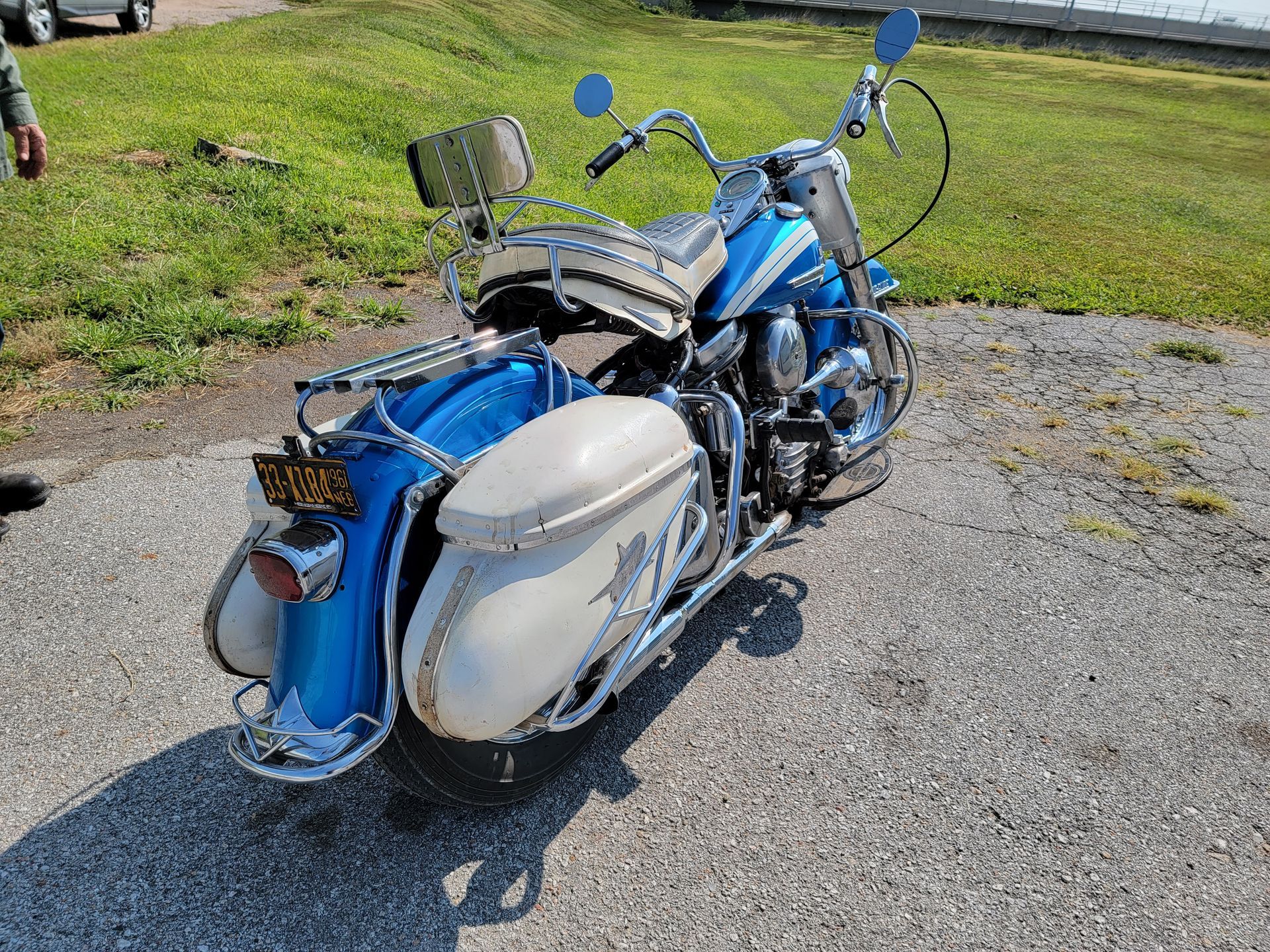 a blue and white motorcycle is parked on the side of the road