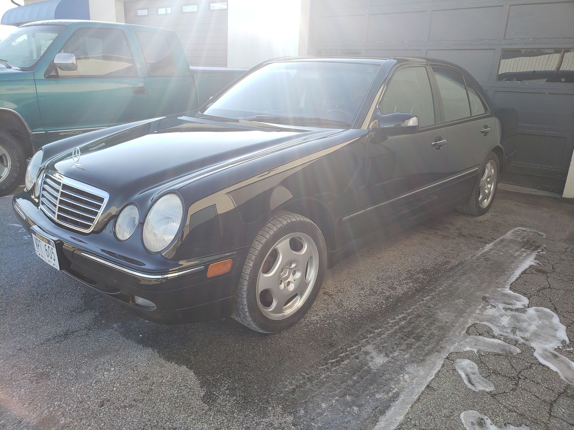 a black mercedes benz is parked in a parking lot