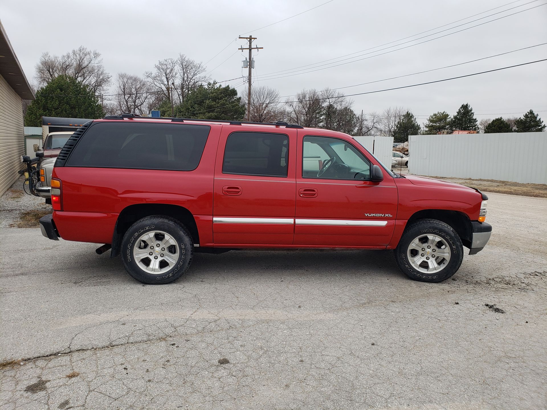 a red chevrolet suburban is parked in a parking lot