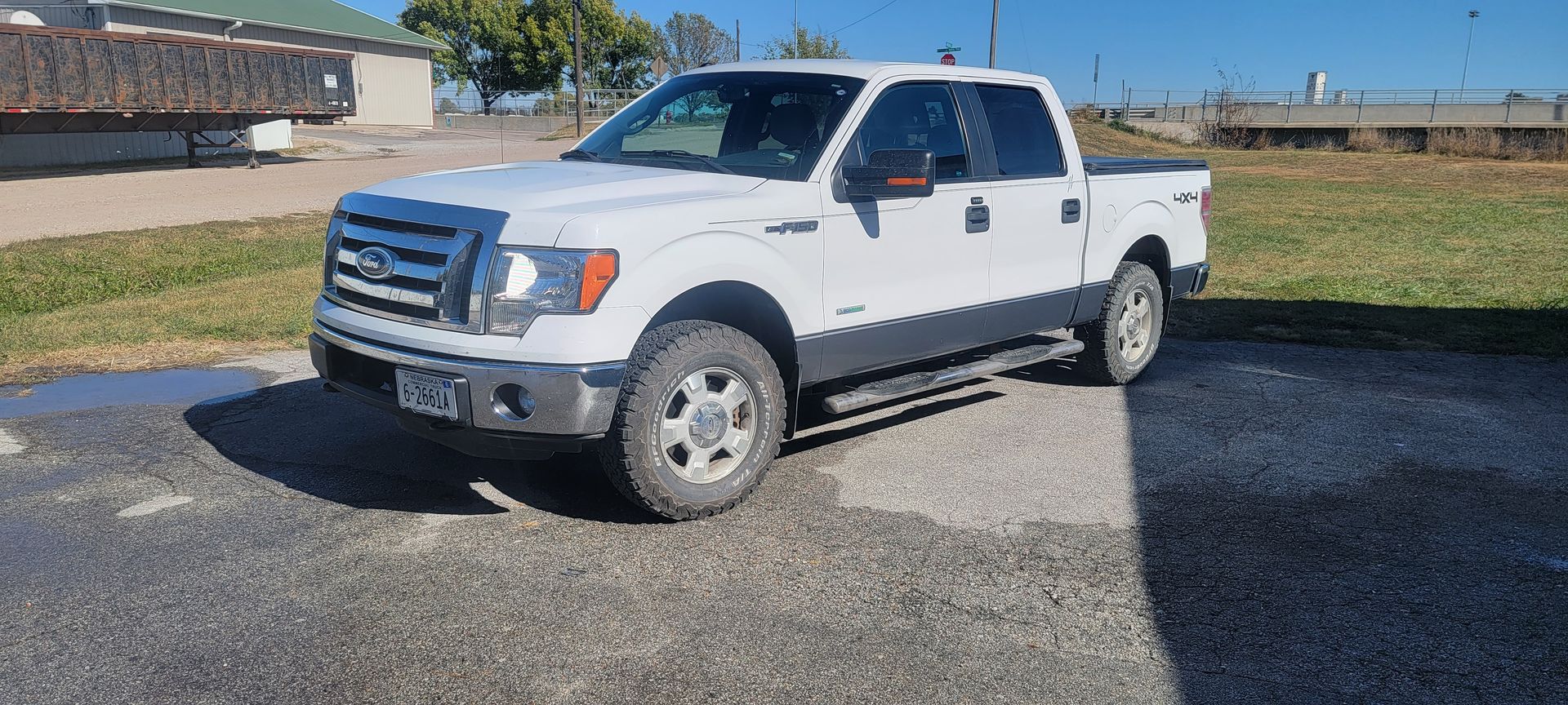a white ford f150 truck is parked in a parking lot