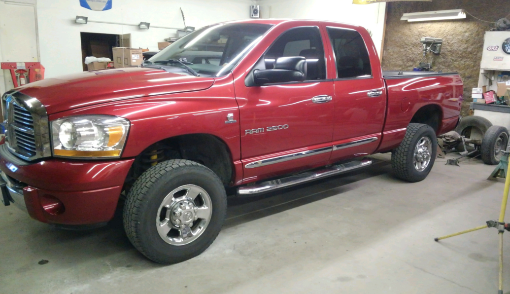 a red dodge ram truck is parked in a garage