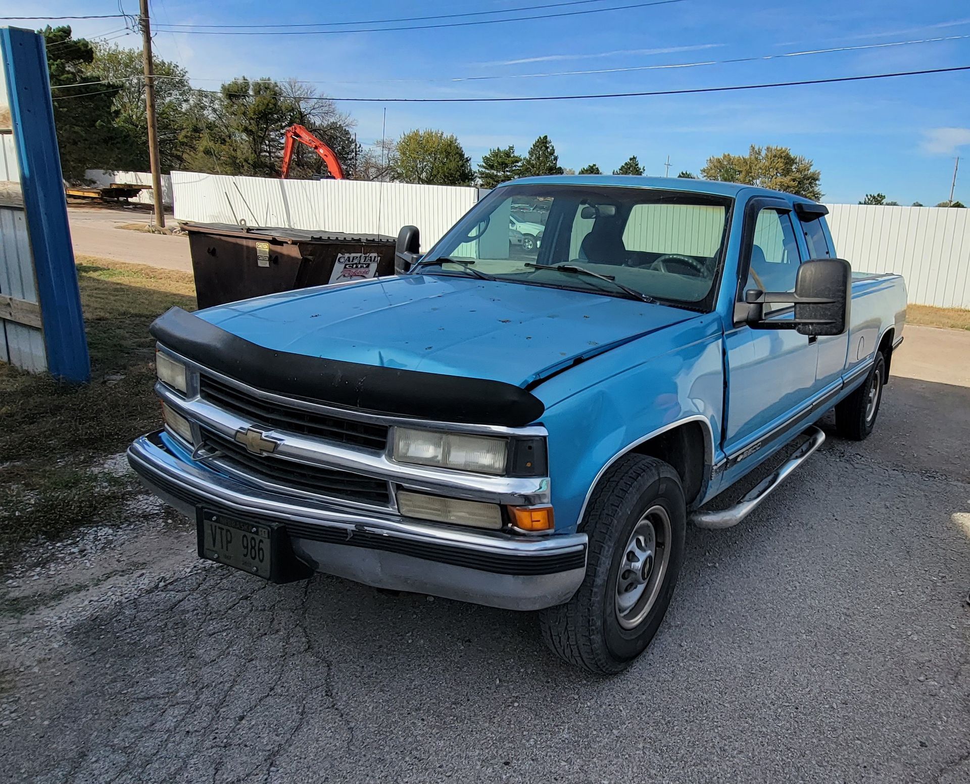 a blue truck is parked on the side of the road