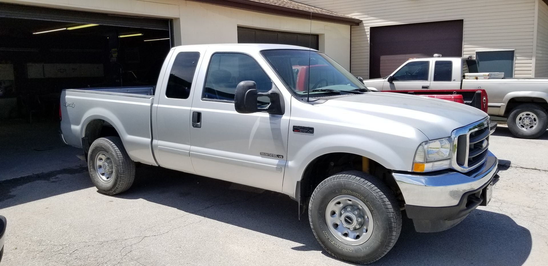 a silver pickup truck is parked in front of a garage