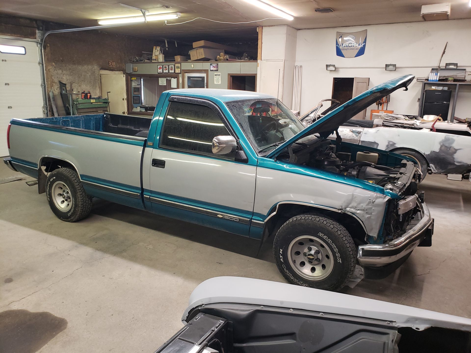 a truck with the hood up is parked in a garage