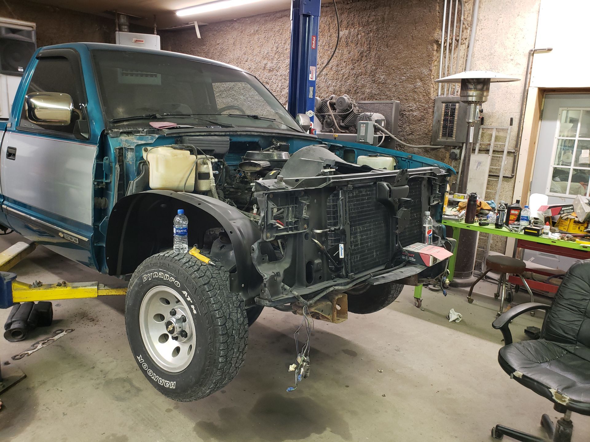 a truck is sitting on a lift in a garage with the hood open