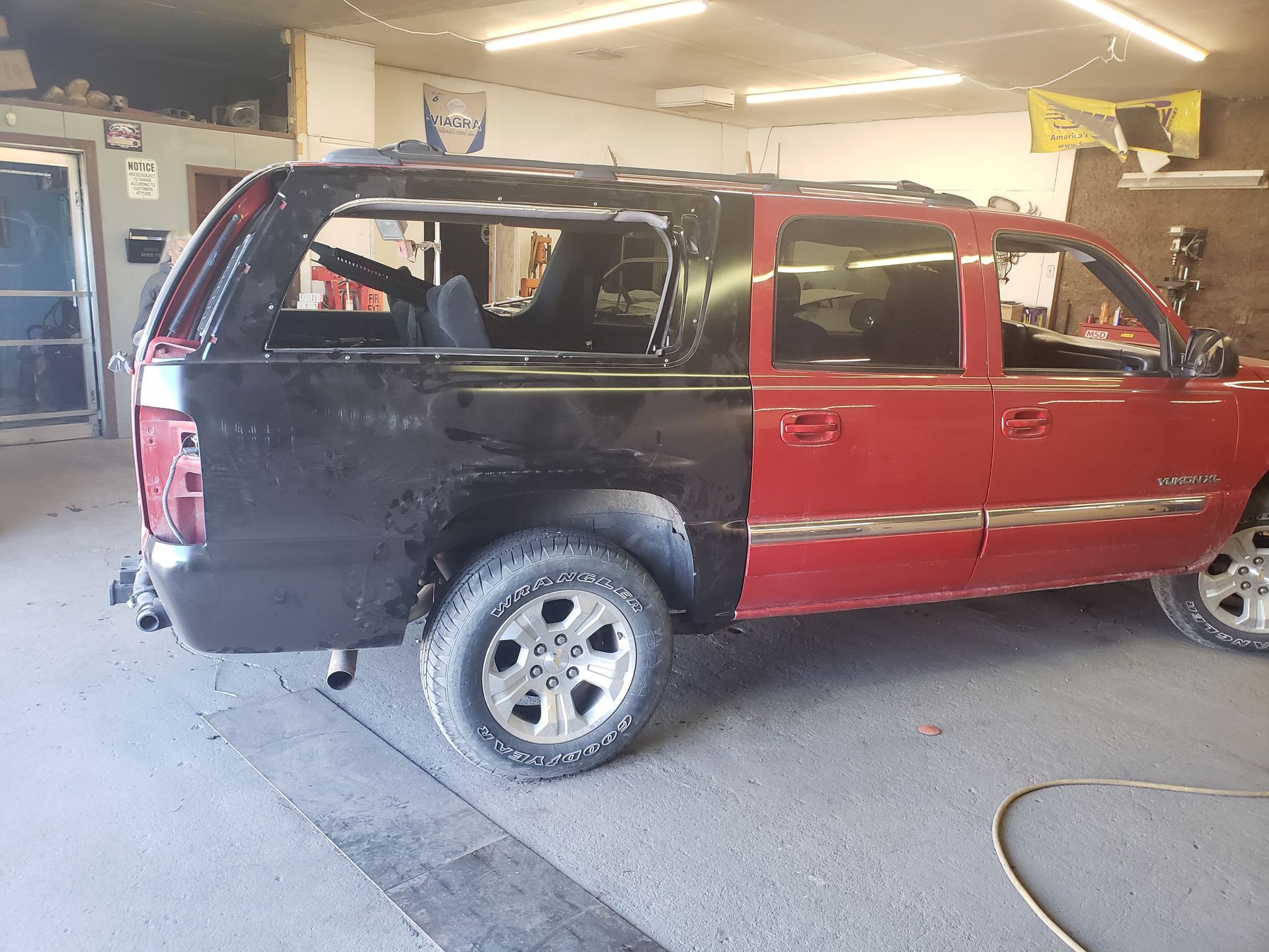 a red suv is being painted black in a garage